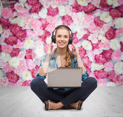 Image of young woman in casual clothes sitting on floor