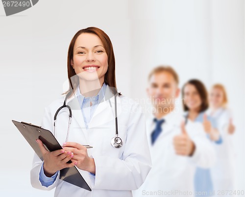 Image of smiling female doctor with clipboard