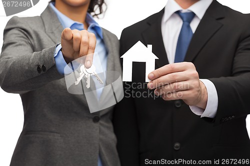 Image of businessman and businesswoman holding white house