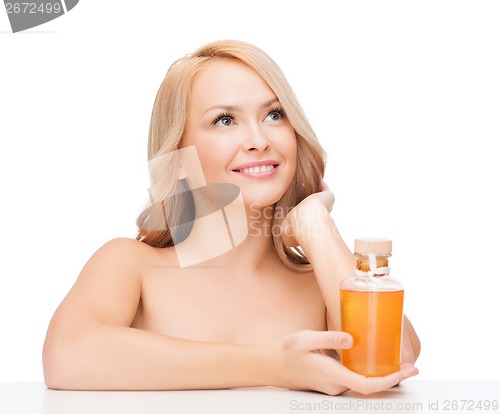 Image of happy woman with oil bottle