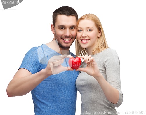 Image of smiling couple holding small red heart
