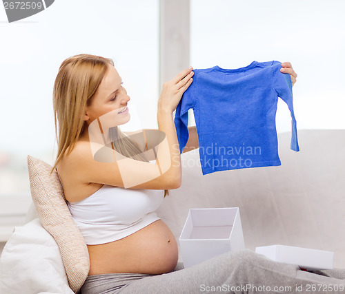 Image of smiling pregnant woman opening gift box