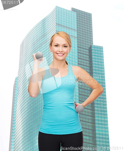 Image of young sporty woman with light dumbbells