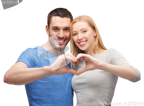 Image of smiling couple showing heart with hands