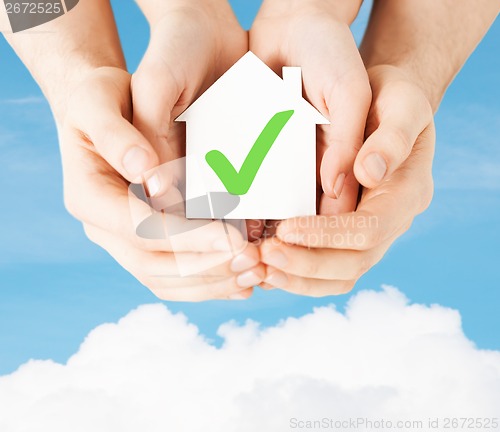 Image of hands holding house with check mark