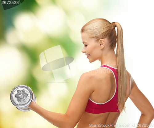 Image of smiling woman with heavy steel dumbbell