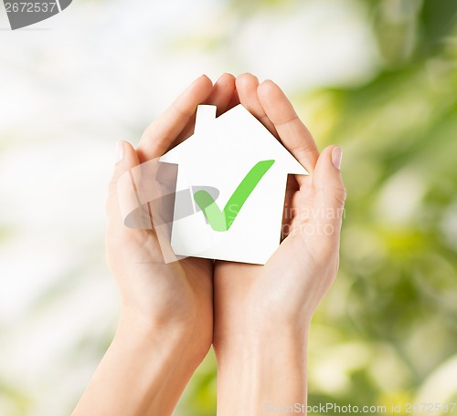 Image of hands holding house with check mark