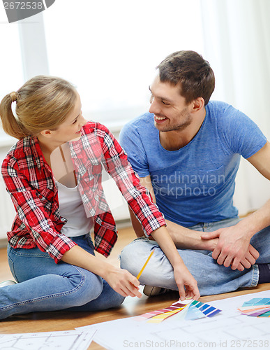 Image of smiling couple looking at color samples at home