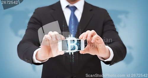 Image of businessman with smartphone and bitcoin on screen