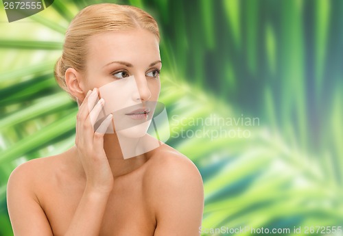 Image of beautiful woman touching her face skin