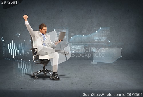 Image of young businessman sitting in chair with laptop