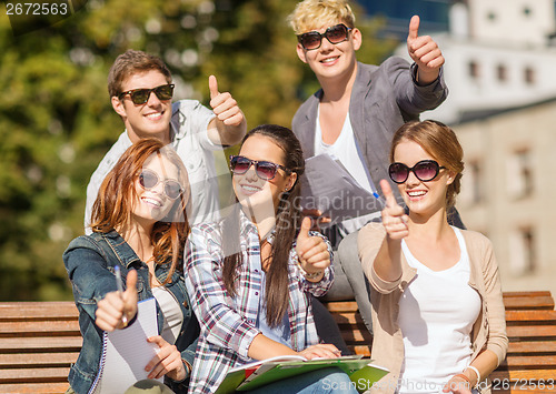 Image of students with books, notebooks, files and folders