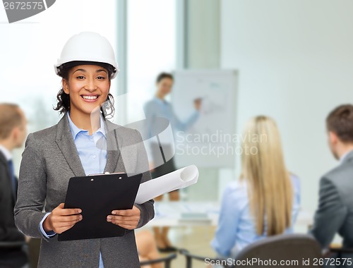 Image of businesswoman in white helmet with clipboard