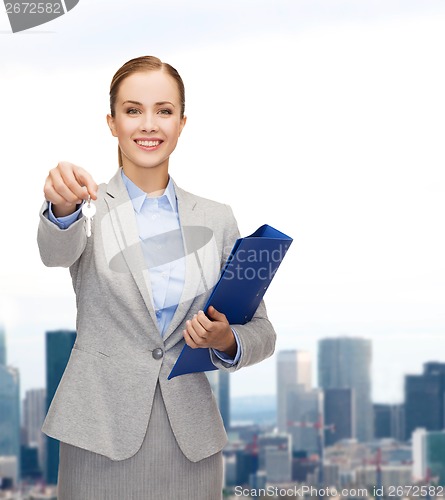 Image of smiling businesswoman with folder and keys