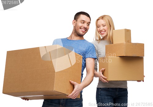 Image of smiling couple holding cardboard boxes