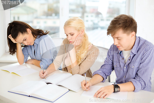 Image of tired students with notebooks at school