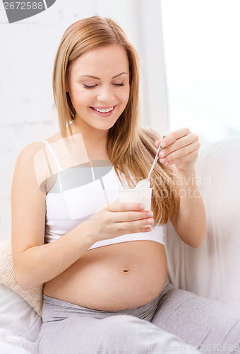 Image of happy pregnant woman with yogurt