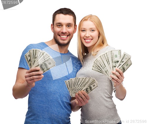 Image of smiling couple holding dollar cash money