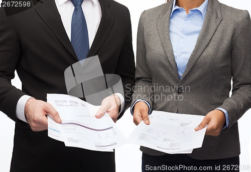 Image of businesswoman and businessman with files and forms