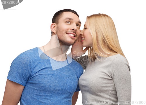 Image of smiling girlfriend telling boyfriend secret