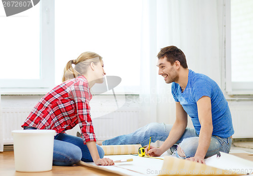 Image of smiling couple measuring wallpaper