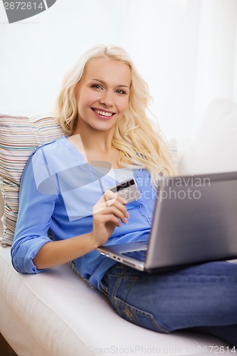 Image of smiling woman with laptop computer and credit card