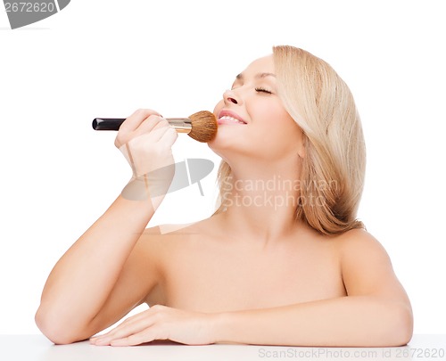 Image of beautiful woman with closed eyes and makeup brush