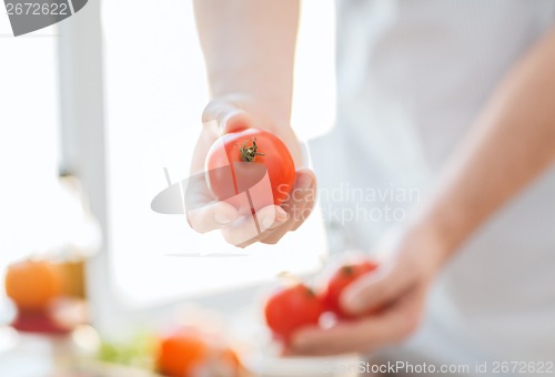 Image of close up of male hands holding tomatoes