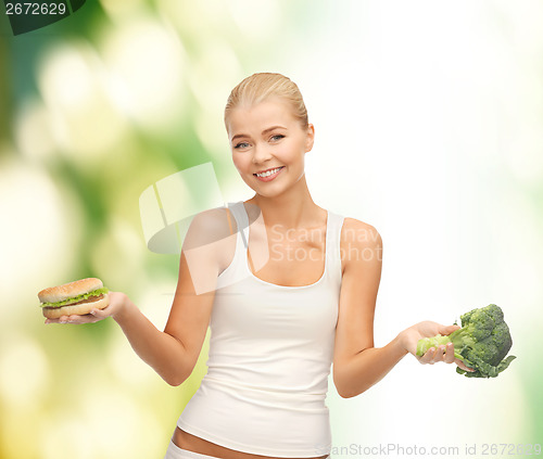 Image of woman with broccoli and hamburger