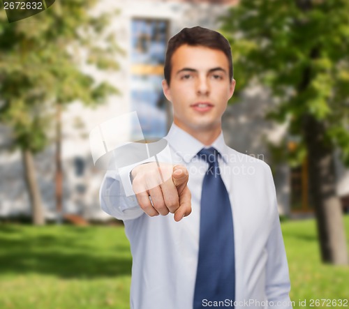 Image of friendly young buisnessman pointing finger