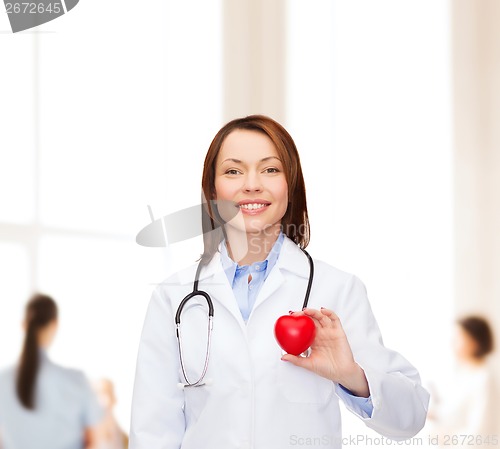 Image of smiling female doctor with heart and stethoscope