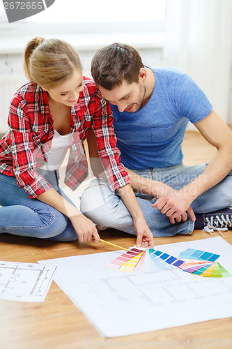 Image of smiling couple looking at color samples at home