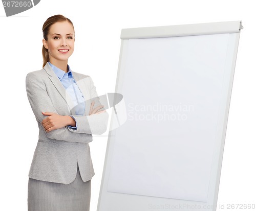 Image of smiling businesswoman standing next to flipboard