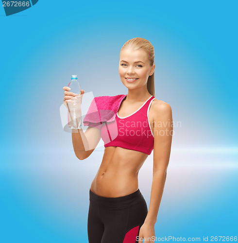 Image of smiling woman with bottle of water and towel