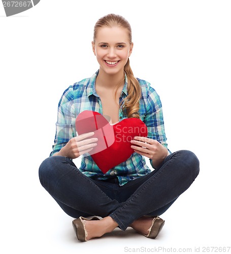 Image of young woman in casual clothes sitting on floor