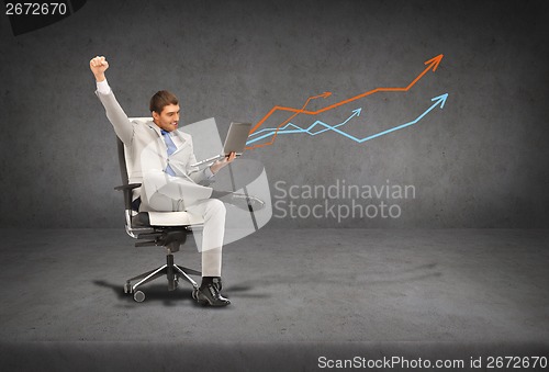 Image of young businessman sitting in chair with laptop