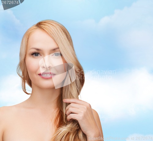 Image of beautiful woman playing with long hair