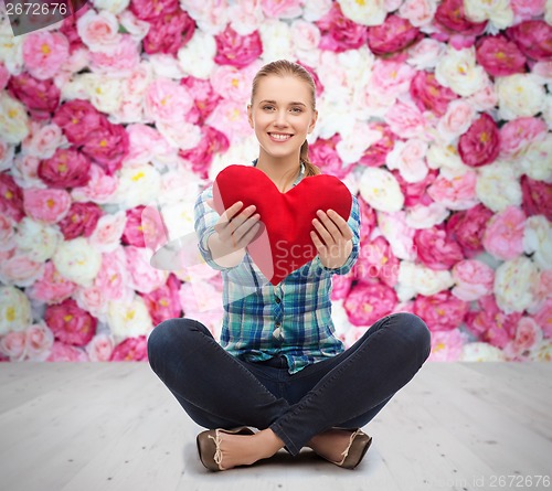 Image of young woman in casual clothes sitting on floor