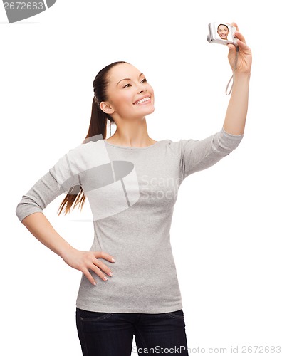 Image of smiling asian woman with digital camera