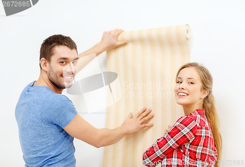 Image of smiling couple choosing wallpaper for new home