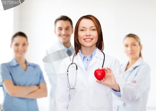 Image of smiling female doctor with heart and stethoscope