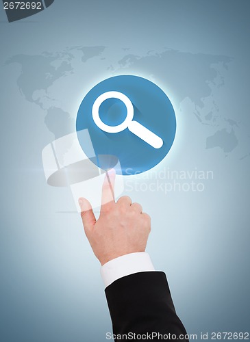 Image of businessman hand pointing to magnifying glass