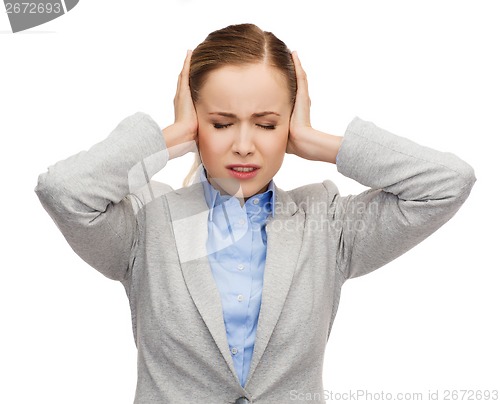 Image of stressed businesswoman with covered ears