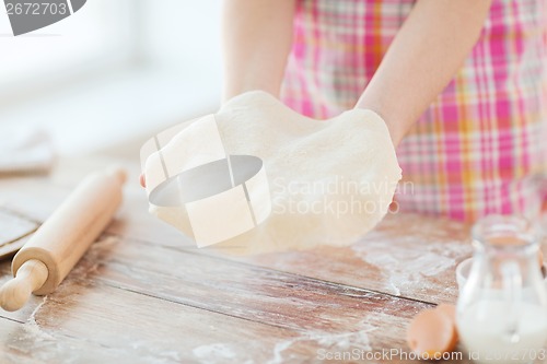 Image of close up of female hands holding bread dough