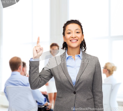 Image of smiling businesswoman with her finger up at office