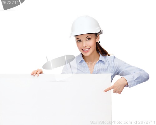 Image of businesswoman in helmet pointing finger to board