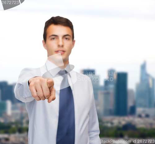 Image of friendly young buisnessman pointing finger