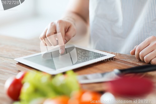 Image of closeup of man pointing finger to tablet pc