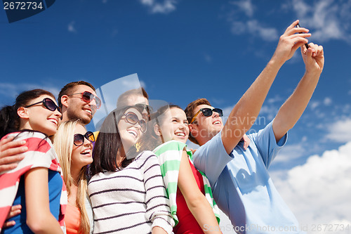 Image of group of friends taking picture with smartphone