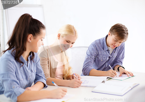 Image of smiling students with notebooks at school